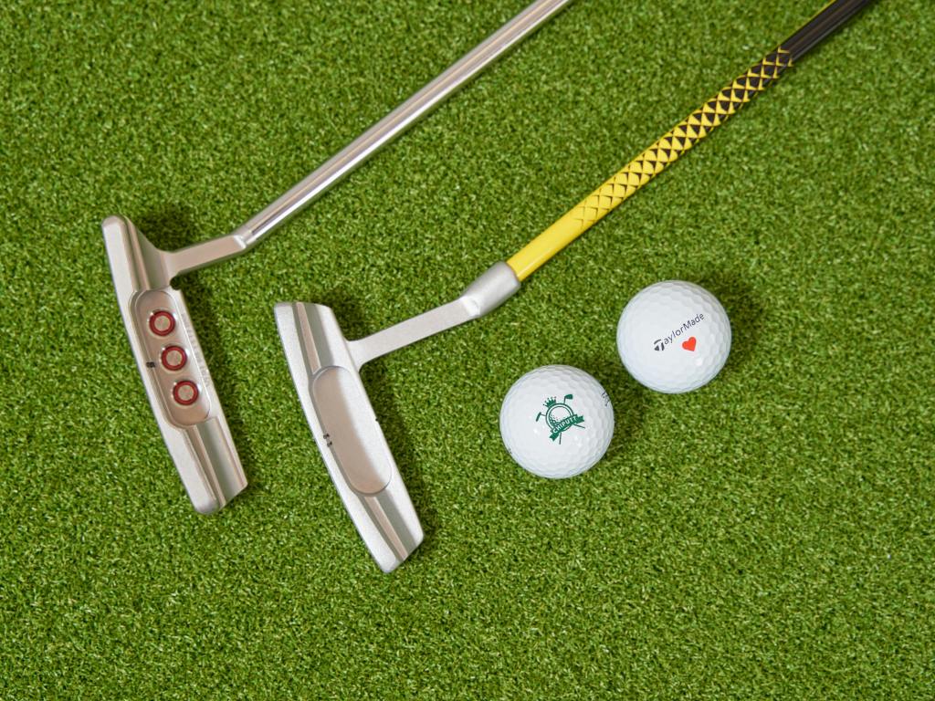 Putter on golf green with golf balls